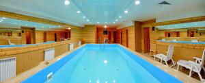 a large swimming pool in a room with a bar at Hotel Saratovskaya in Saratov