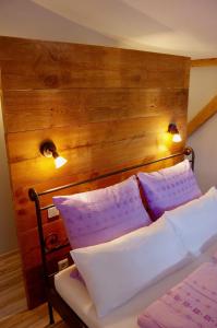 ラウターバッハにあるUrlaubsbahnhof-Gueterbodenのベッド1台(木製ヘッドボード、紫と白の枕付)