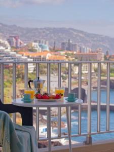 una mesa con un bol de fruta en el balcón en Apartamentos do mar, en Funchal