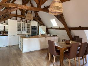 cocina con armarios blancos y mesa de madera en Aux 3 Maillets en Bourges