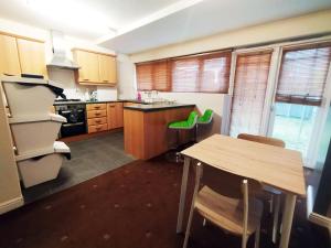 a kitchen with a wooden table and a wooden counter top at Bankwell Guest House in Manchester