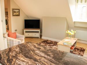 a living room with a flat screen tv and a couch at Orchard Apartment in Shrewsbury