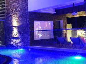 a house with a swimming pool with a projection screen at G R A N D C H A L E T in Salalah