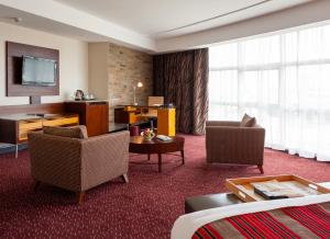 um quarto de hotel com duas cadeiras e uma televisão em The Boma Nairobi em Nairobi