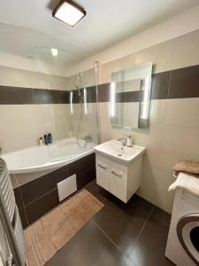 een badkamer met een bad, een wastafel en een bad bij Angel Apartment Černý důl in Cerny Dul