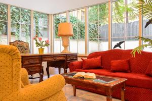 a living room with a red couch and a table at Hotel Malá Strana in Prague