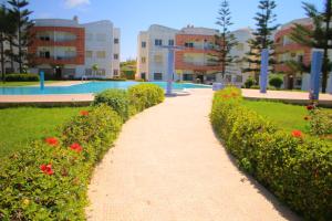 a pathway in front of a building with flowers at Mohammedia pour les vacances in Mohammedia