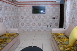 a room with a couch and a tv on a wall at Mohammedia pour les vacances in Mohammedia