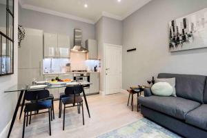 a kitchen and a living room with a couch and a table at Bright and Modern Bayswater Apartment in London