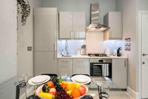 a kitchen with a bowl of fruit on a glass table at Bright and Modern Bayswater Apartment in London