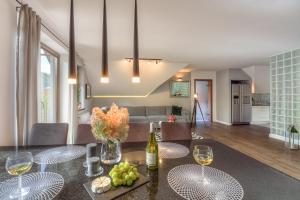 a dining room and living room with a table with wine glasses at Apartament 7.0 in Roztoka Wielka