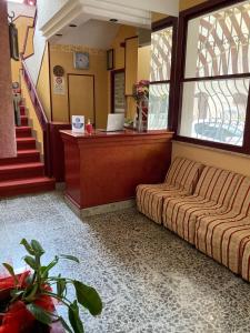 a waiting room with a couch and a desk at Hotel Villa Sorci in Rimini