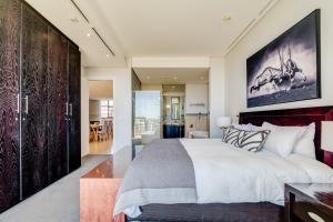 a bedroom with a large bed and a living room at Juliette B 606 in Cape Town