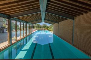 une piscine intérieure avec un mur en briques et des fenêtres dans l'établissement Antica Villa Merelli 24, Emma Villas, à Monte San Savino