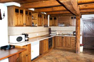 a kitchen with wooden cabinets and a microwave at Baba Stana Houses in Apriltsi
