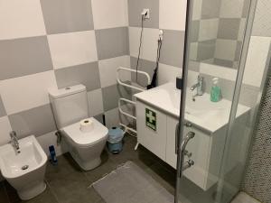Un baño con inodoro, lavabo y ducha. en Liberty Guest House, en Ponte de Sor 4 fotos más