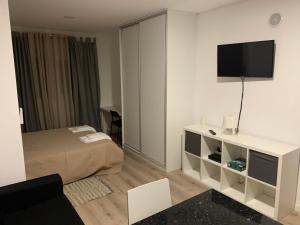 a hotel room with a bed and a television on the wall at Liberty Guest House in Ponte de Sor