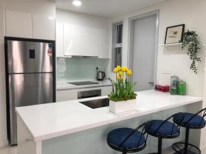 a white kitchen with a sink and a refrigerator at JW Homestay The Ridge KL East in Kuala Lumpur