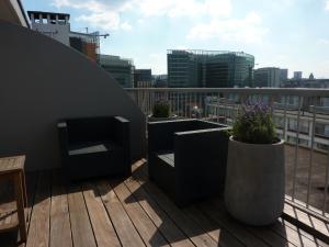 een balkon met stoelen en potplanten op een gebouw bij New Hotel Charlemagne in Brussel