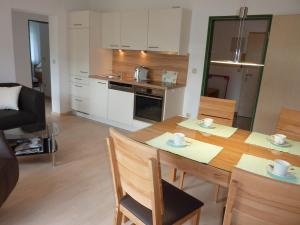 a kitchen and dining room with a table and chairs at Apartmenthaus Sonnenschein - Chiemgau Karte in Inzell