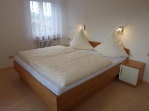Säng eller sängar i ett rum på Apartmenthaus Sonnenschein - Chiemgau Karte