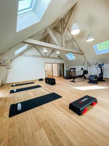 a gym with yoga mats in a room with skylights at Domaine Du Roncemay - Hôtel, Restaurants, Spa & Golf in Aillant-sur-Tholon