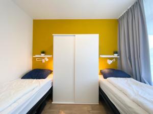 twee bedden in een kamer met gele muren bij Vakantieappartement Westkapelle WE07 in Westkapelle