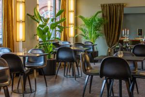 a restaurant with tables and chairs and plants at Hotel Astoria, Best Western Signature Collection in Copenhagen