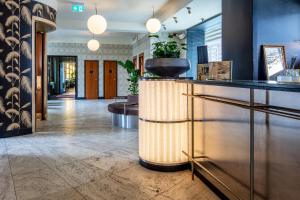 a lobby with a reception counter and a hallway with tables at Hotel Astoria, Best Western Signature Collection in Copenhagen