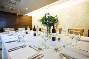 a table with wine glasses and a vase of flowers at Trearddur Bay Hotel in Trearddur