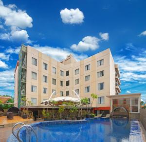 een hotel met een zwembad voor een gebouw bij Sapphire Sky Hotel & Conference in Serpong