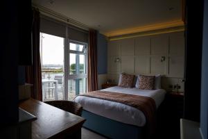 a hotel room with a bed and a large window at Trearddur Bay Hotel in Trearddur