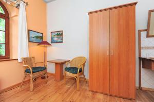 a room with a table and chairs and a cabinet at Pension Altes Posthaus in Dangast