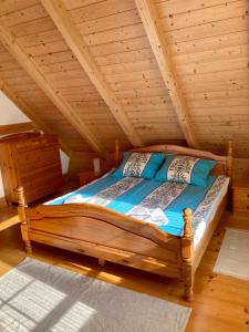 a bedroom with a wooden bed in a attic at KASZUBSKA CHATA in Lubiatowo
