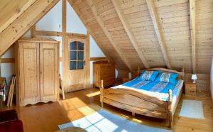 a bedroom with a bed in a wooden attic at KASZUBSKA CHATA in Lubiatowo
