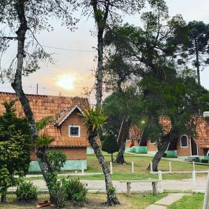 a house in the middle of a yard with trees at Pousada Vale Verde in Monte Verde