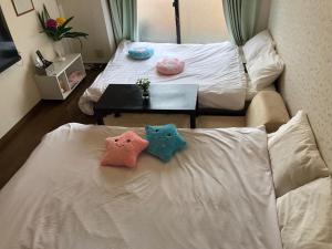 two pillows sitting on a bed in a room at 駅南うちやまビルさん in Fukuoka