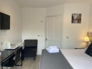 una camera d'albergo con letto, scrivania e sedia di Miller House Courtyard ad Ayr