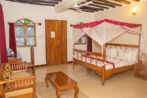 a bedroom with a bed with a canopy at Sunbrella Boutique Hotel in Michamvi