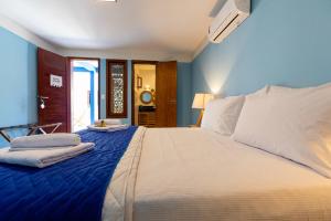 una camera da letto con un letto grande con pareti blu di Caminho da Praia BG a Barra Grande Altre 62 foto