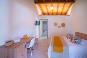 a bedroom with a bed and a table and a desk at Su Cappeddu Agriturismo in San Giorgio
