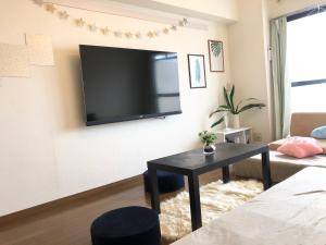 a living room with a flat screen tv on the wall at 駅南うちやまビルさん in Fukuoka
