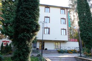 a building seen through the trees at Лісовий готель Гайки in Zhytomyr