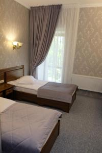 ein Hotelzimmer mit 2 Betten und einem Fenster in der Unterkunft Лісовий готель Гайки in Schytomyr