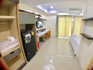 Habitación pequeña con nevera y escritorio. en AP Grand Residence en Rayong