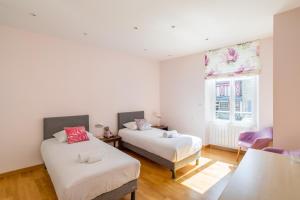 a bedroom with two beds and a window at La Dame de la Mer - en plein cœur de Dinard in Dinard