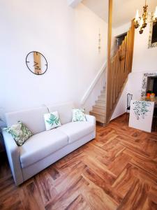 uma sala de estar com um sofá branco e pisos em madeira em Charming Portuguese style apartment, for rent "Vida à Portuguesa", "Fruta or Polvo" Alojamento Local em Portimão