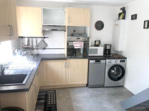 une cuisine avec une machine à laver et un lave-linge dans l'établissement Maison confortable à Saint-Cyprien avec piscine partagée, à Saint-Cyprien 9 autres photos