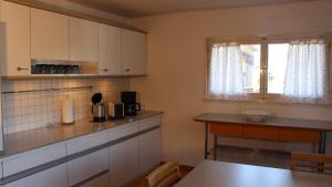 a kitchen with white cabinets and a table and a window at Appartement Maria in Egg