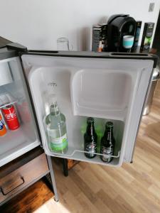 an open refrigerator with bottles of water in it at Stylisches kleines Studio -Zentral gelegen in Leverkusen Wiesdorf - Friedrich Ebert Platz 5a , 4te Etage mit Balkon--Kaution Pflicht-- in Leverkusen